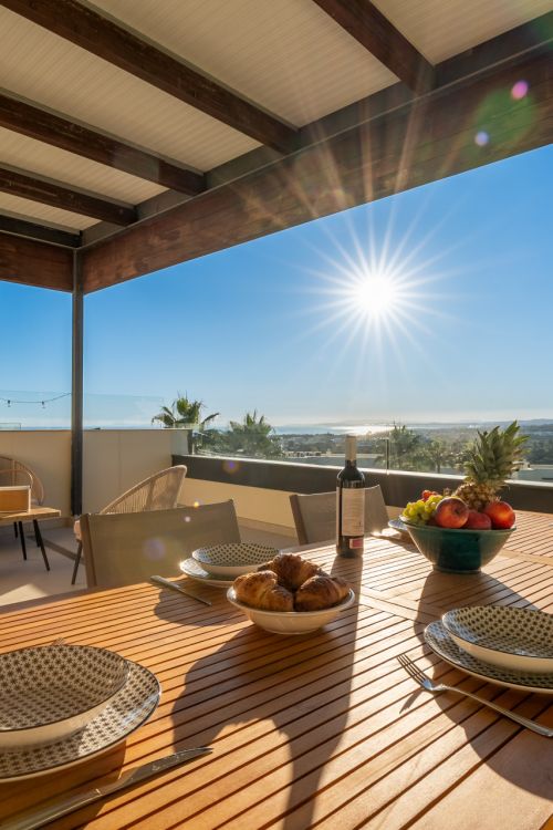 Two-bedroom apartment with panoramic golf and sea views in gated Los Flamingos, Benahavís. 37 m² terrace, 2 parking spaces, 2 storage rooms — and a proven rental track record of over €40,000 gross per year.