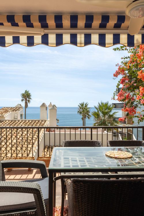 Vistas panorámicas al mar, una amplia terraza, comedor al aire libre y una piscina comunitaria en Calahonda.